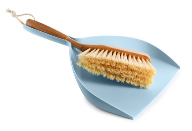 Light blue dustpan and wooden brush on white background