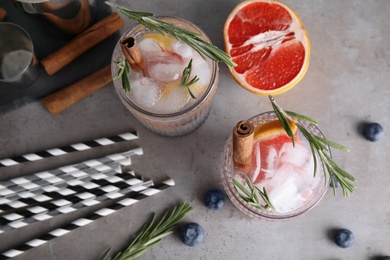 Photo of Flat lay composition with glasses of grapefruit and rosemary cocktail on gray table