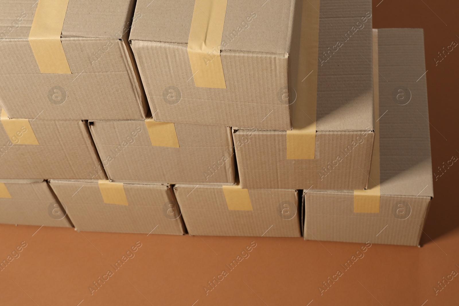 Photo of Stack of many cardboard boxes on brown background, above view