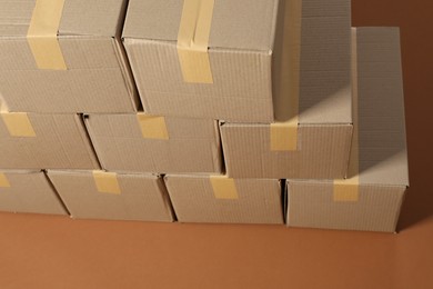 Stack of many cardboard boxes on brown background, above view