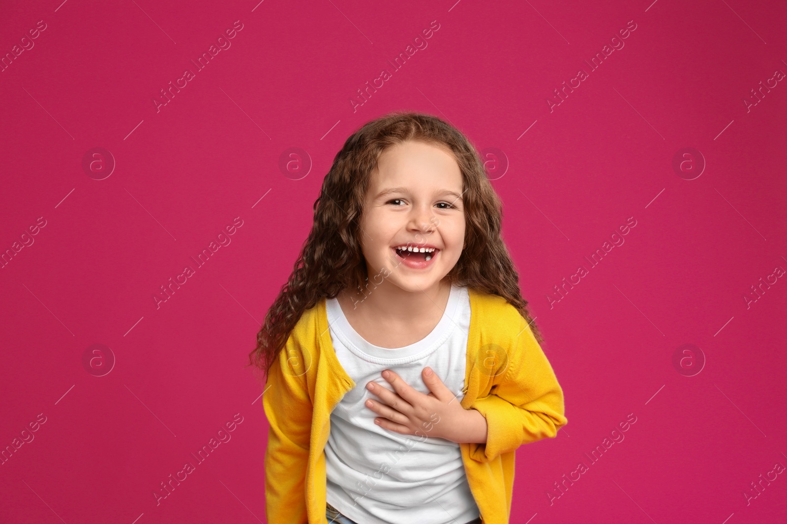 Photo of Portrait of cute little girl on pink background