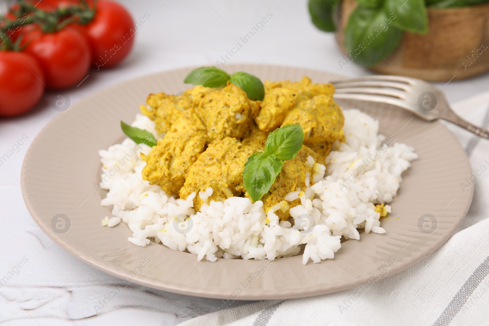 Photo of Delicious rice and chicken with curry sauce on white textured table, closeup