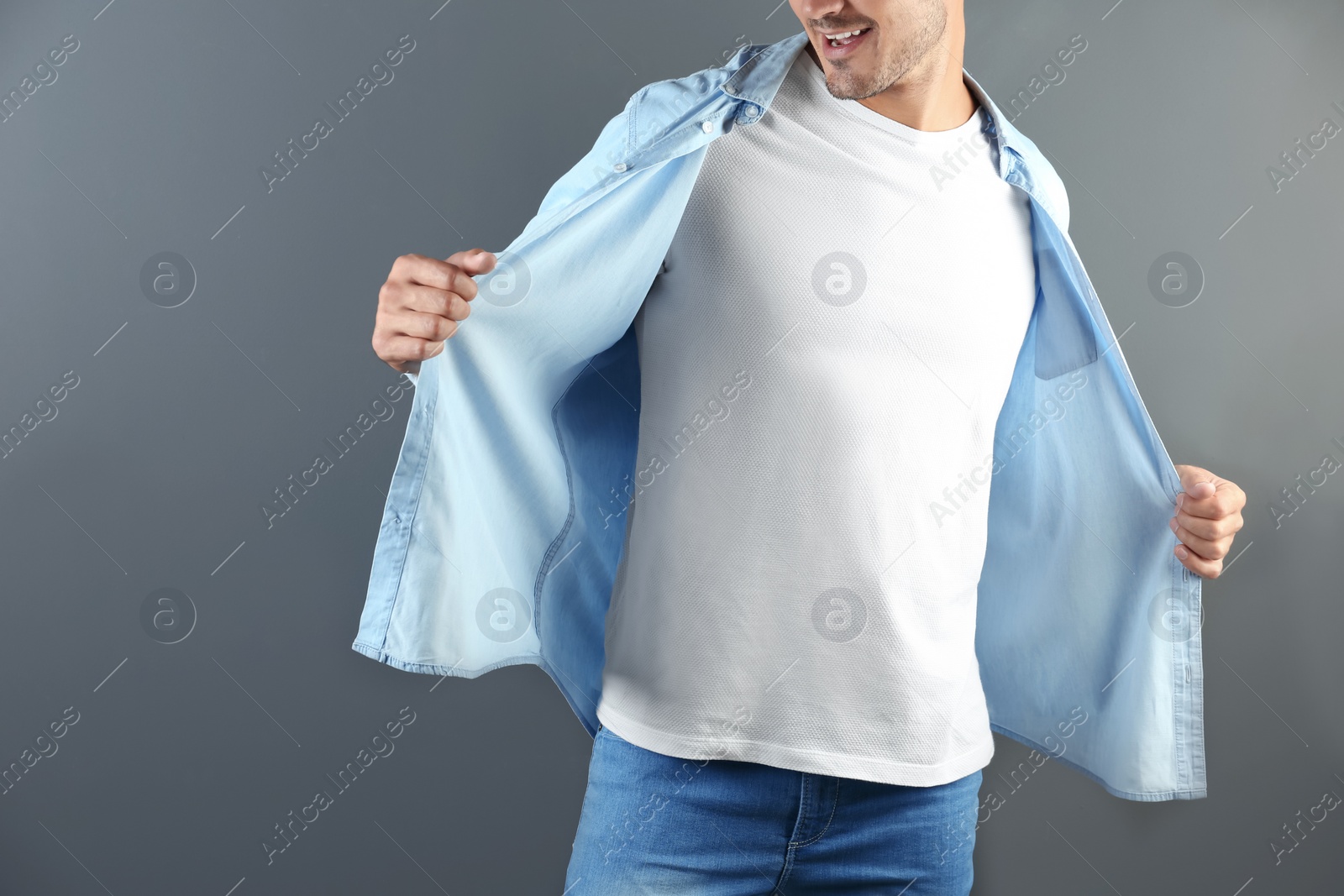 Photo of Young man in t-shirt on grey background. Mockup for design