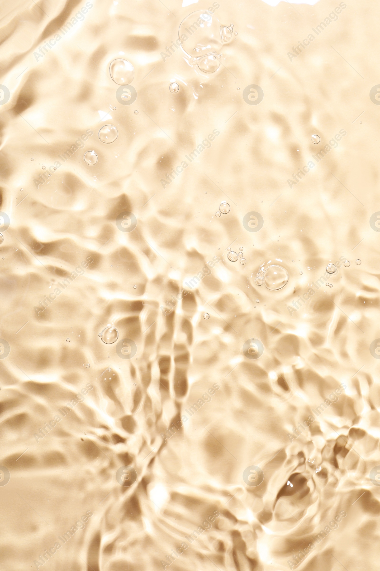 Photo of Closeup view of water with rippled surface on beige background