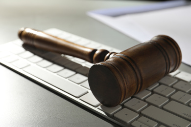 Photo of Gavel and computer keyboard on grey table. Cyber crime