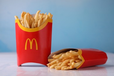 Photo of MYKOLAIV, UKRAINE - AUGUST 12, 2021: Two big portions of McDonald's French fries on white table
