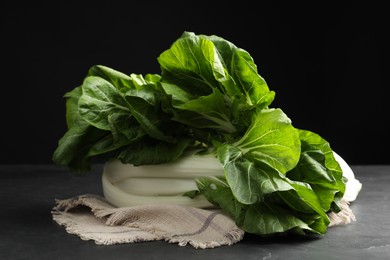 Photo of Fresh green pak choy cabbages on black table