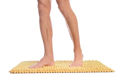 Photo of Man standing on soft yellow bath mat against white background, closeup