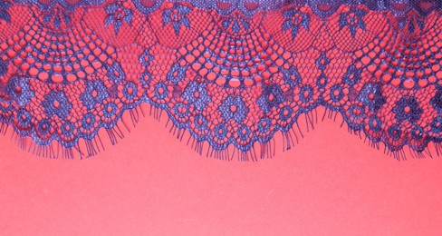 Photo of Blue lace on red background, top view. Space for text