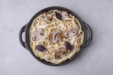 Photo of Delicious pasta with mushrooms on light grey table, top view