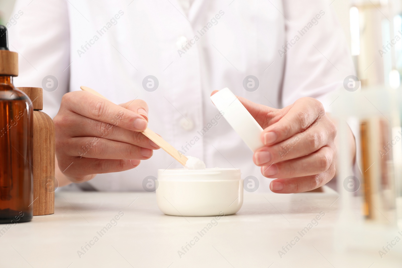 Photo of Dermatologist developing cosmetic product at light table, closeup