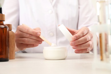 Photo of Dermatologist developing cosmetic product at light table, closeup