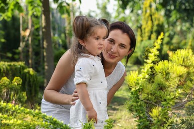 Mother with her cute daughter spending time together in park