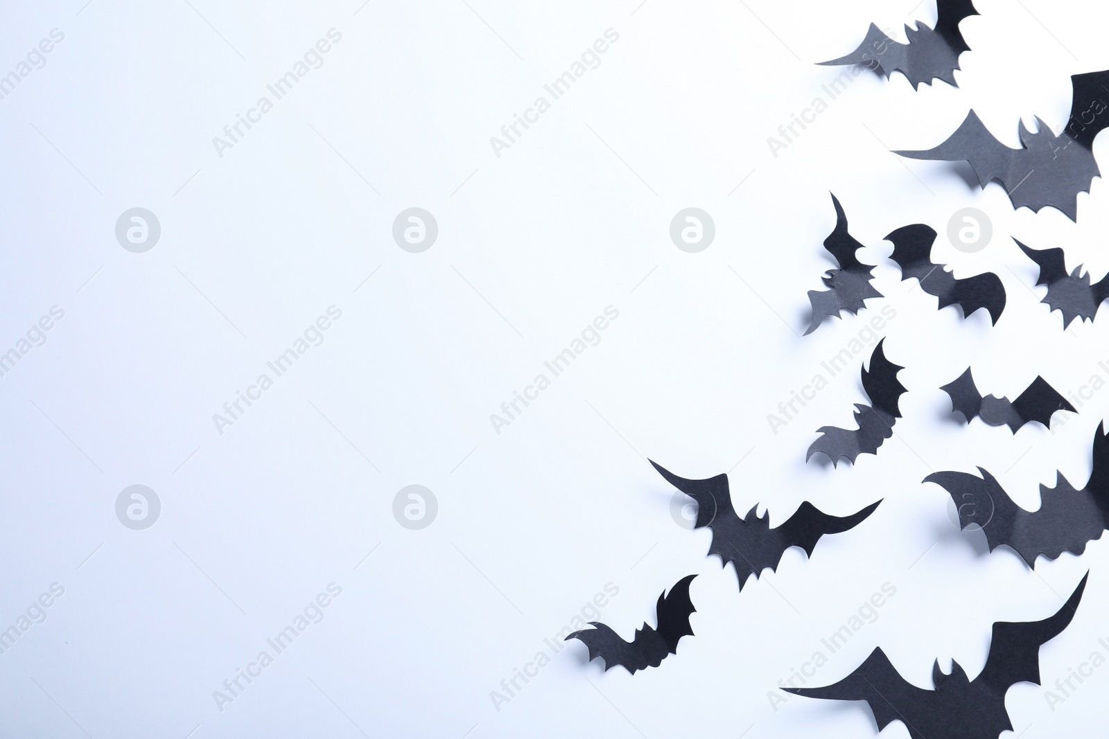 Photo of Many black paper bats on white background, flat lay with space for text. Halloween decor