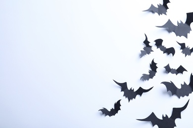 Photo of Many black paper bats on white background, flat lay with space for text. Halloween decor