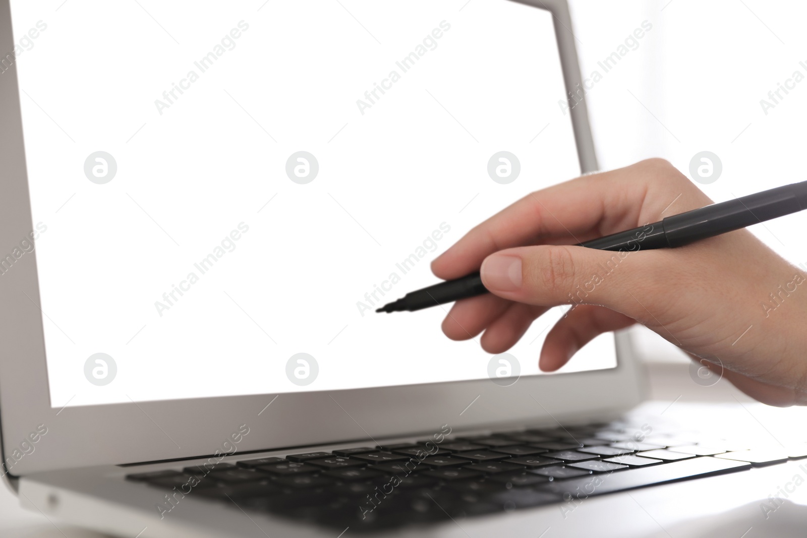 Photo of Woman pointing at modern laptop with blank screen, closeup