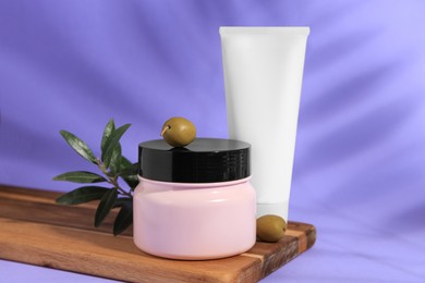 Photo of Cosmetic products and olives on lilac background
