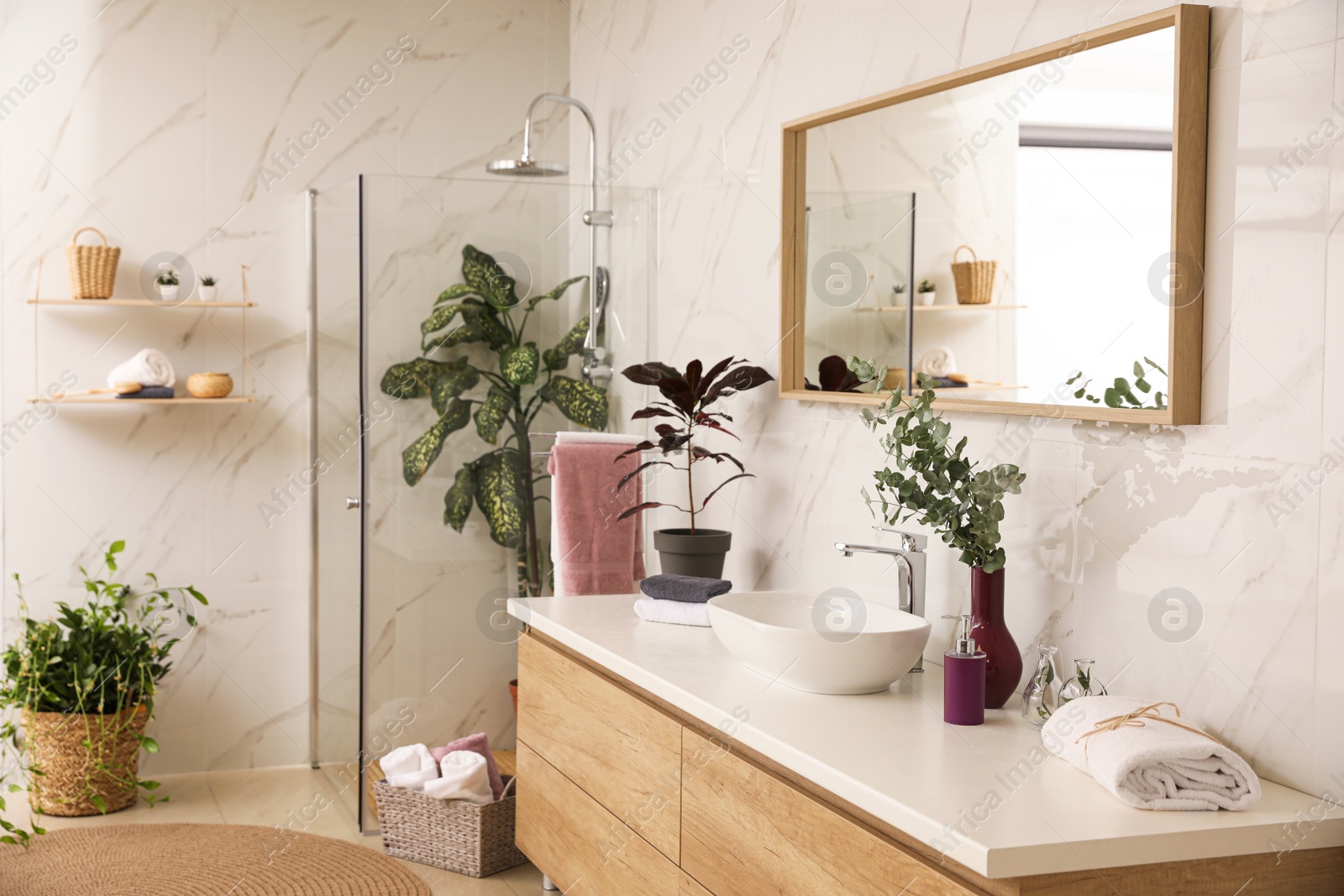 Photo of Stylish bathroom interior with countertop, shower stall and houseplants. Design idea