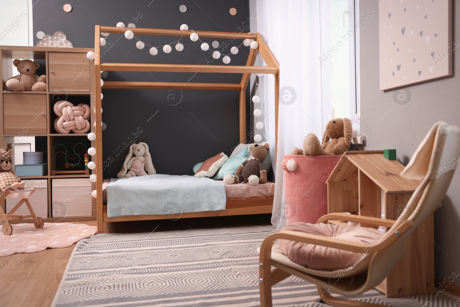 Photo of Comfortable house bed in child room. Stylish interior