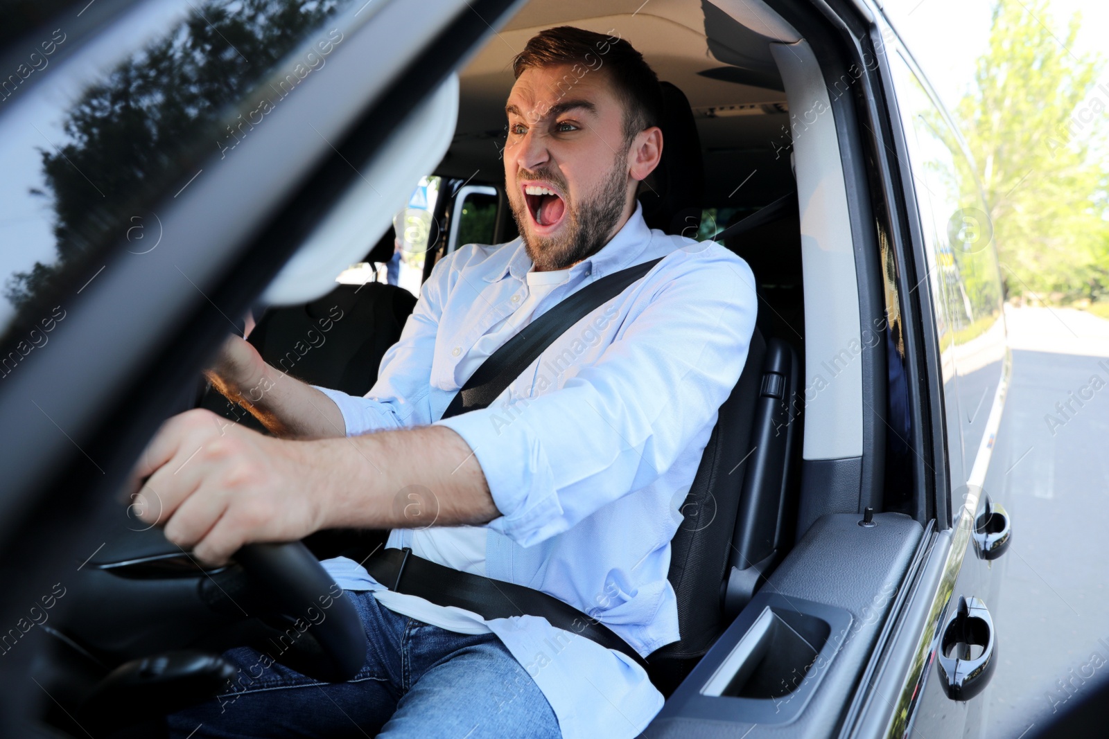 Photo of Emotional man in car. Aggressive driving behavior