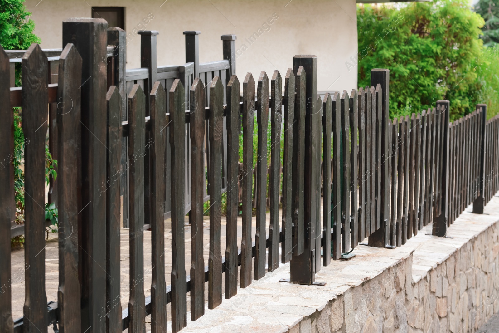 Photo of Low wooden shabby fence near building outdoors