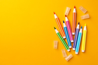 Photo of Many bright markers on yellow background, flat lay. Space for text