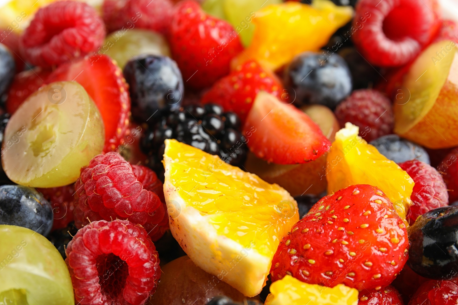 Photo of Fresh tasty fruit salad as background, closeup