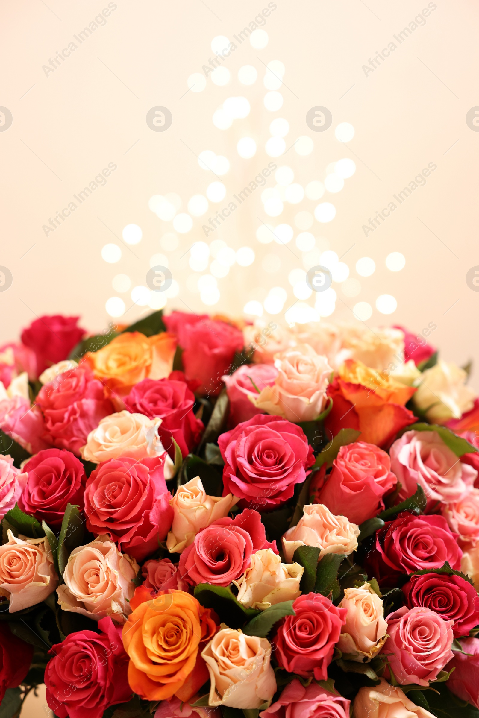 Photo of Beautiful bouquet of colorful roses on beige background