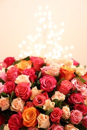 Photo of Beautiful bouquet of colorful roses on beige background