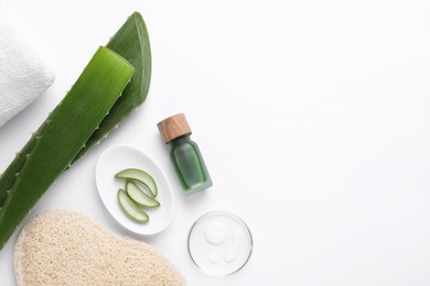 Cosmetic products and cut aloe leaves on white background, flat lay. Space for text