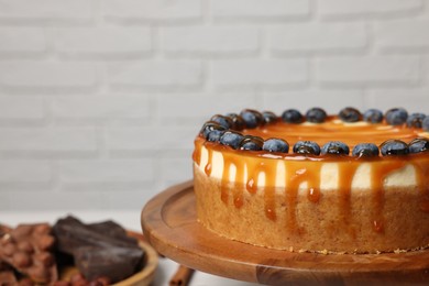 Photo of Delicious cheesecake with caramel and blueberries, closeup. Space for text