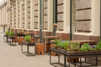 Photo of Wooden stools and tables near cafeteria outdoors