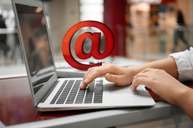 Woman sending email via laptop in cafe, closeup