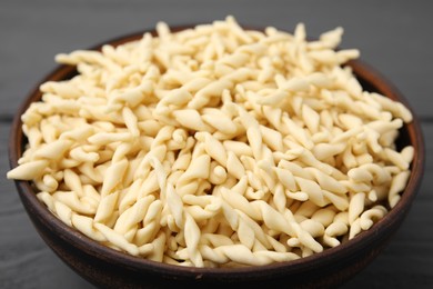 Uncooked trofie pasta in bowl on table, closeup