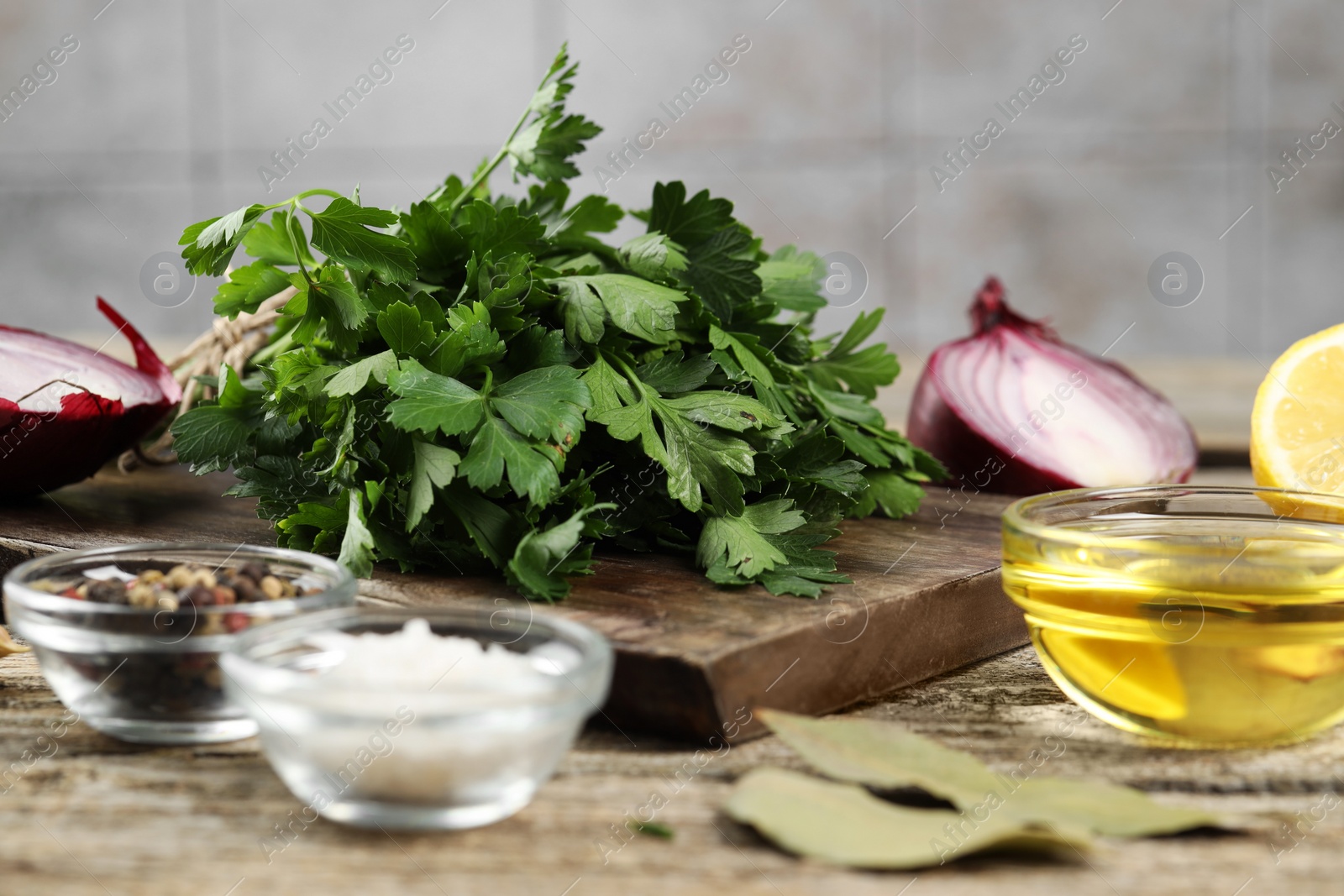 Photo of Board with fresh parsley, spices and other products on wooden table, closeup