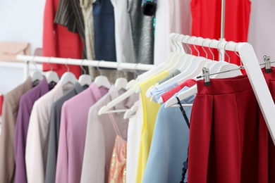 Racks with stylish clothes in boutique, closeup