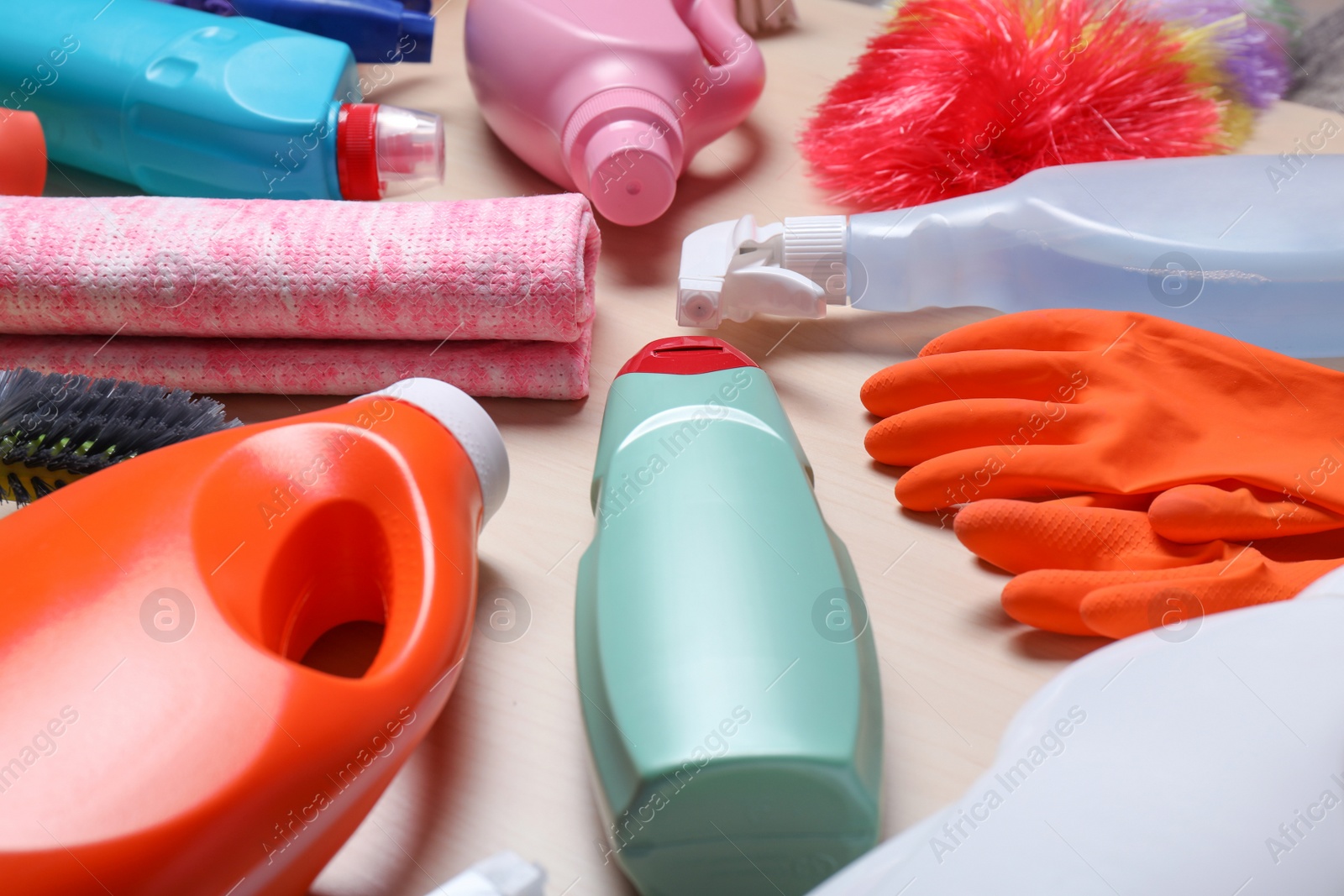 Photo of Set of cleaning supplies on wooden background, closeup