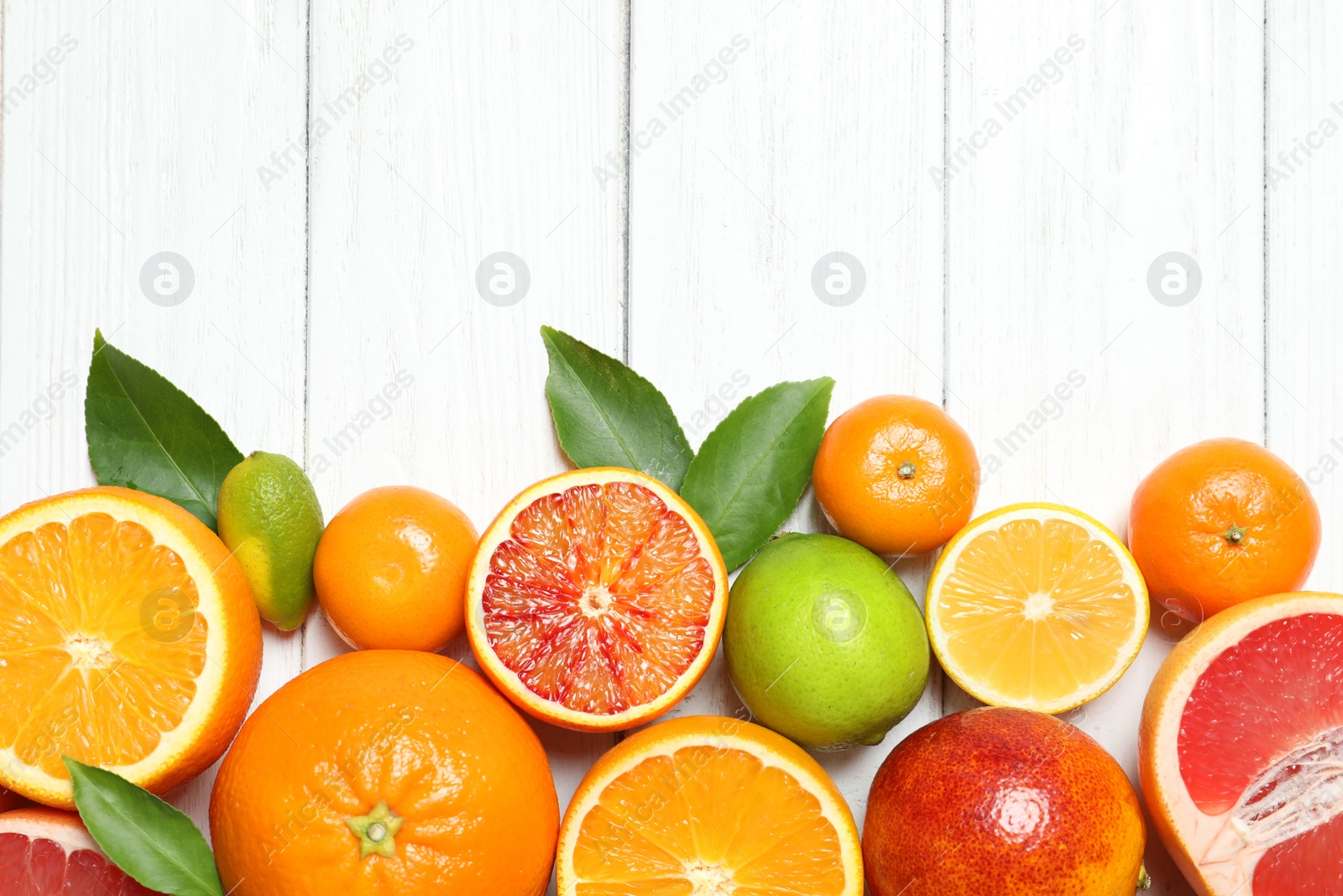 Photo of Flat lay composition with different citrus fruits and space for text on white wooden background