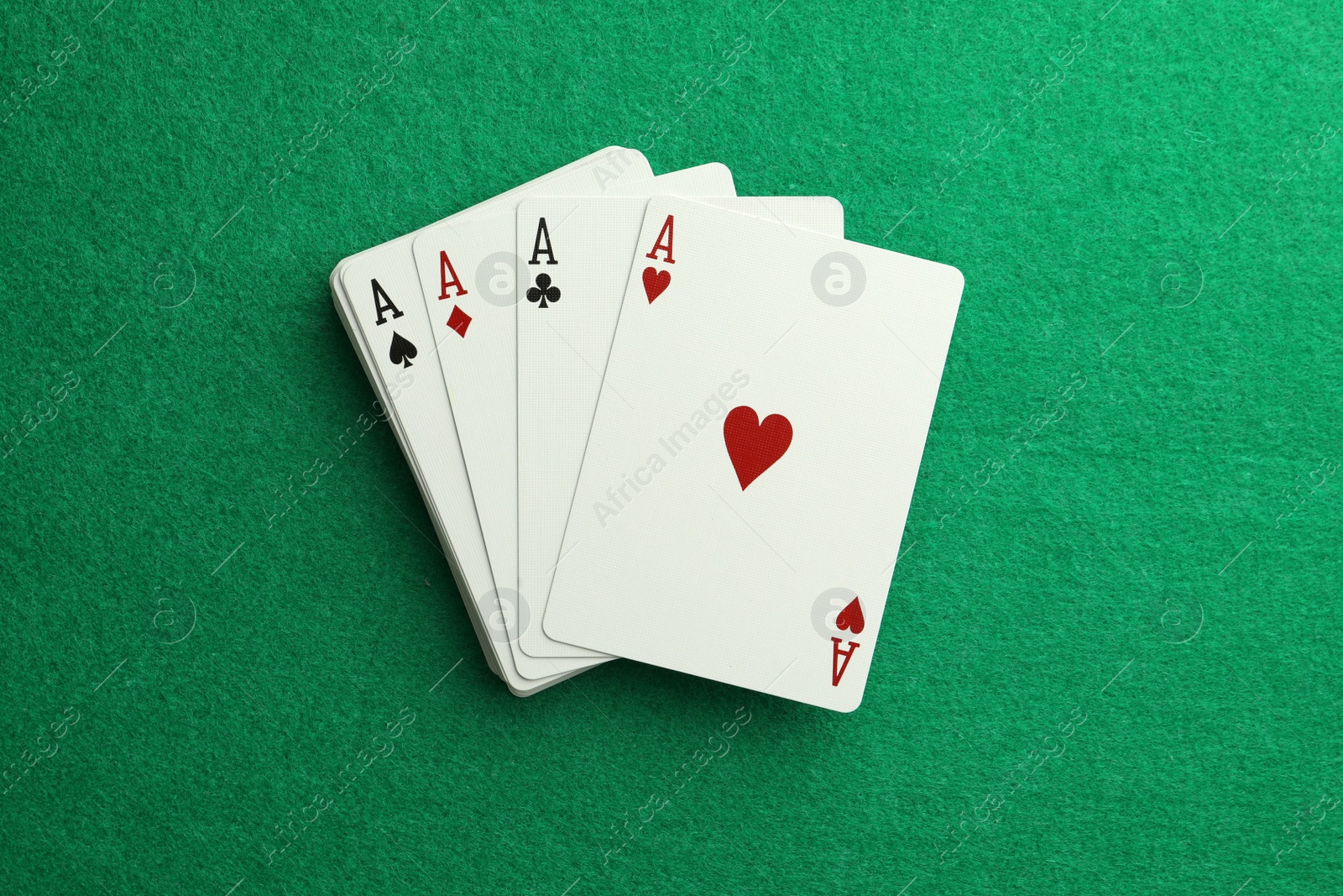 Photo of Four aces playing cards on green table, top view. Poker game