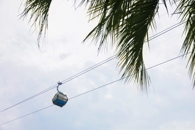 Photo of Cableway with cabin against cloudy sky, low angle view