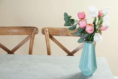 Photo of Vase with beautiful flowers as element of interior design on table in room. Space for text