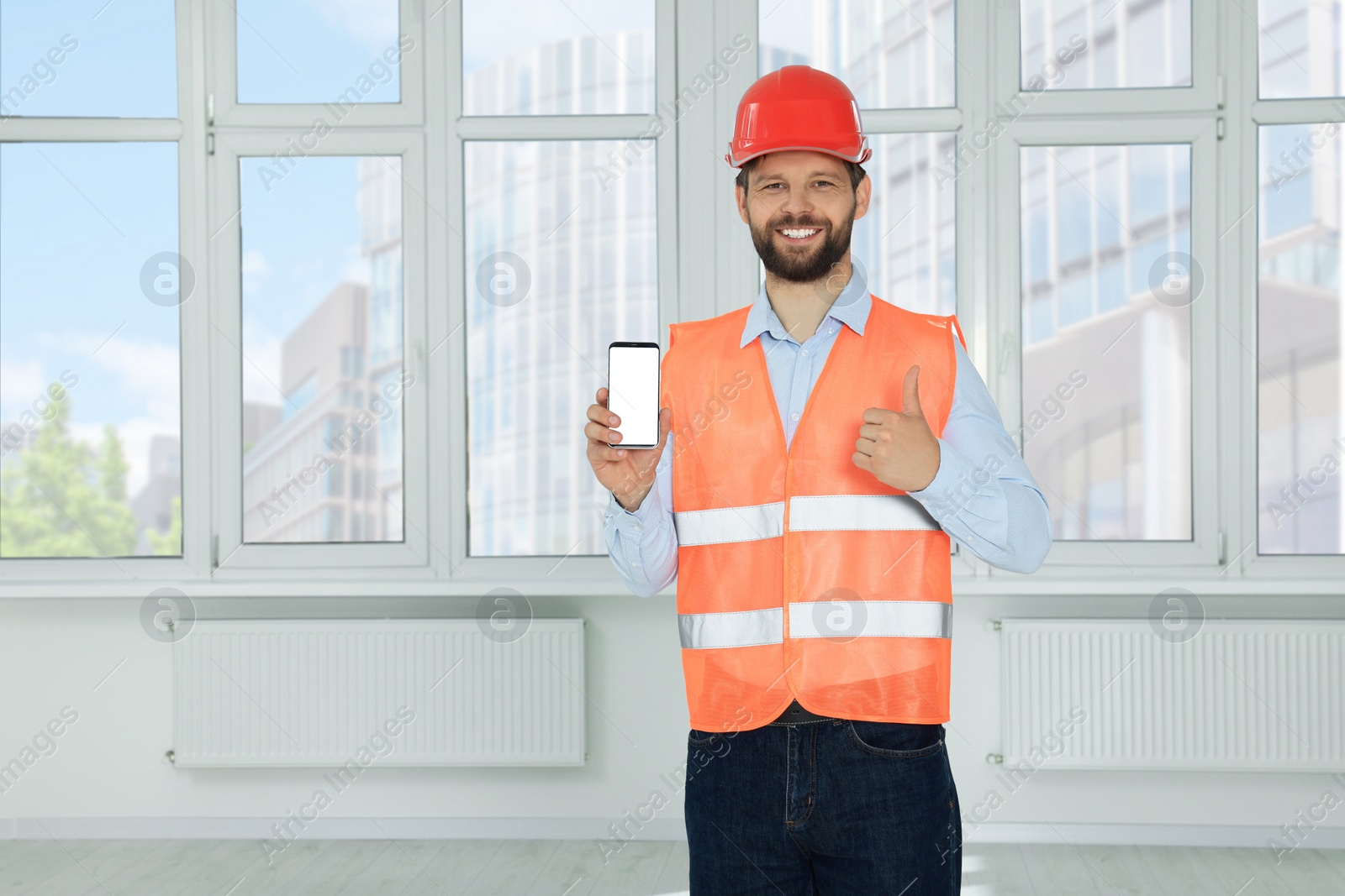 Photo of Man in reflective uniform with phone indoors