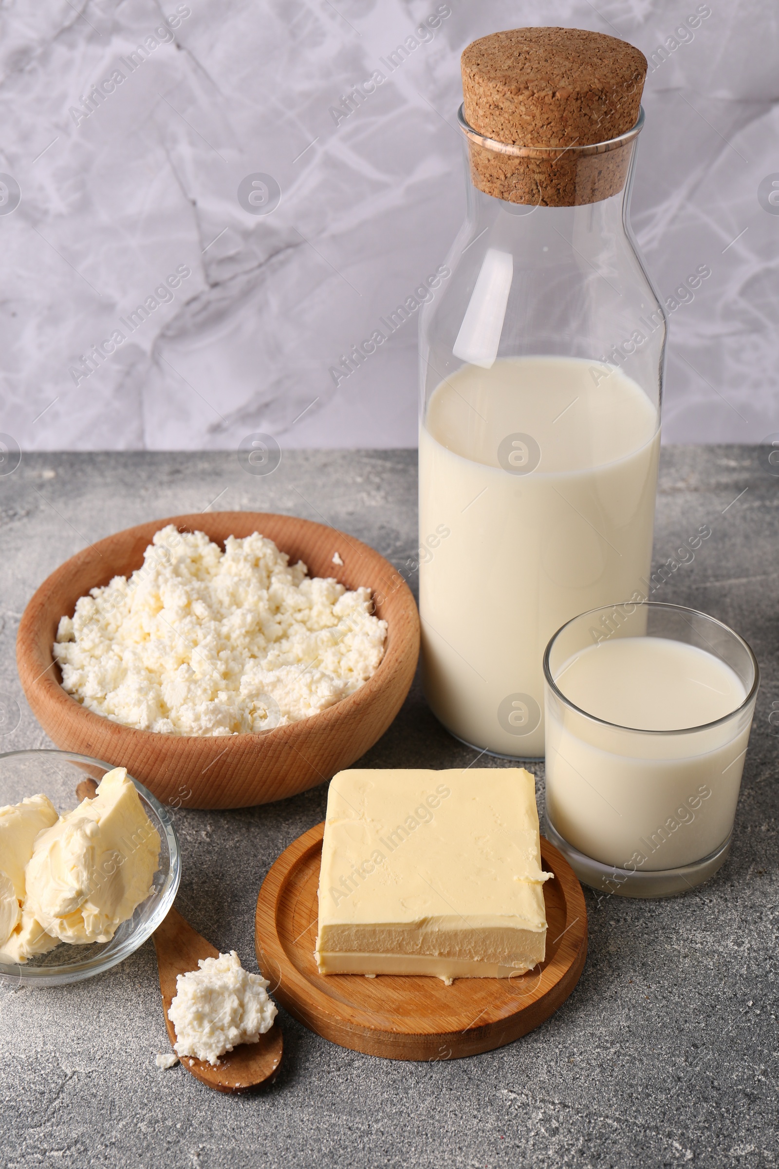 Photo of Piece of tasty homemade butter and dairy products on grey table