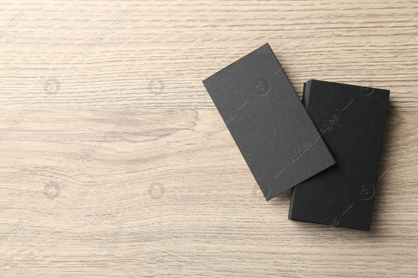 Photo of Blank black business cards on wooden table, top view. Mockup for design