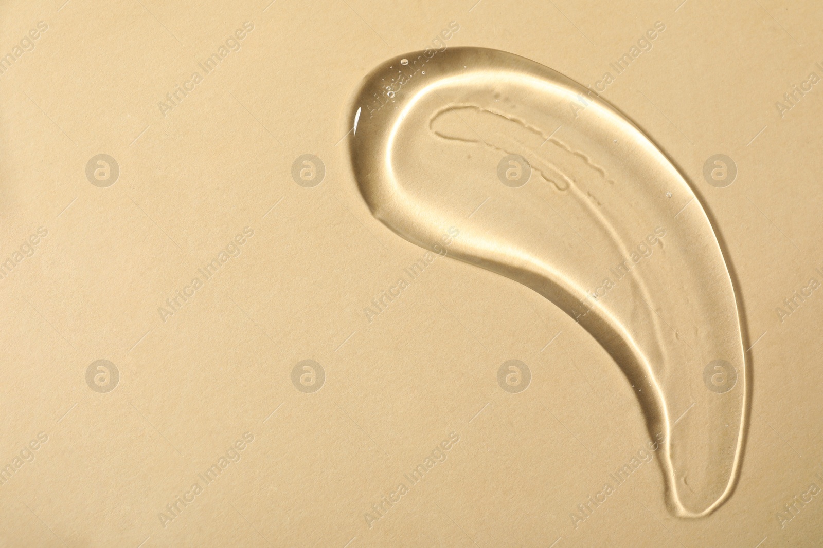 Photo of Sample of transparent cosmetic gel on beige background, top view. Space for text