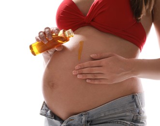 Photo of Young pregnant woman with sun protection oil on white background, closeup