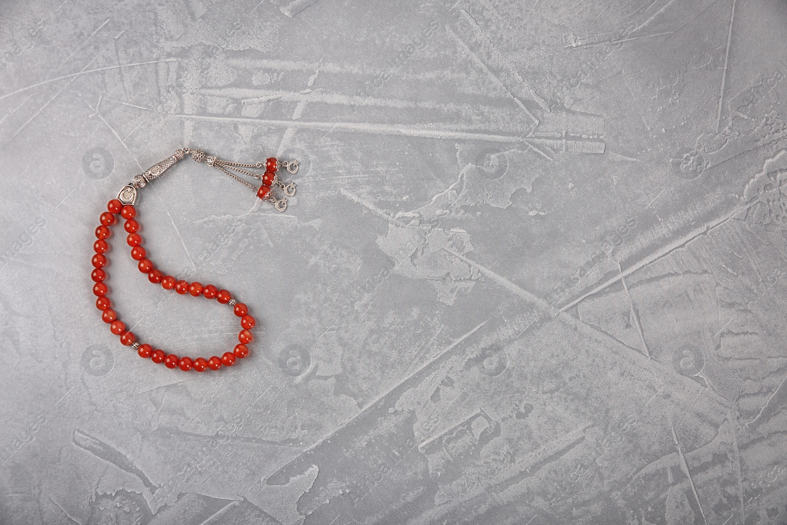 Photo of Muslim prayer beads and space for text on grey background, top view