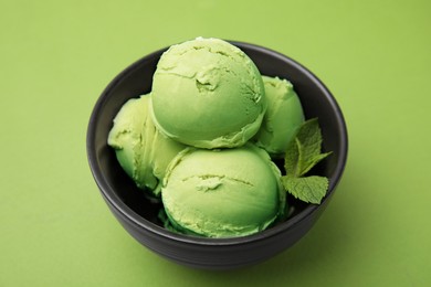 Photo of Tasty matcha ice cream in bowl on green table