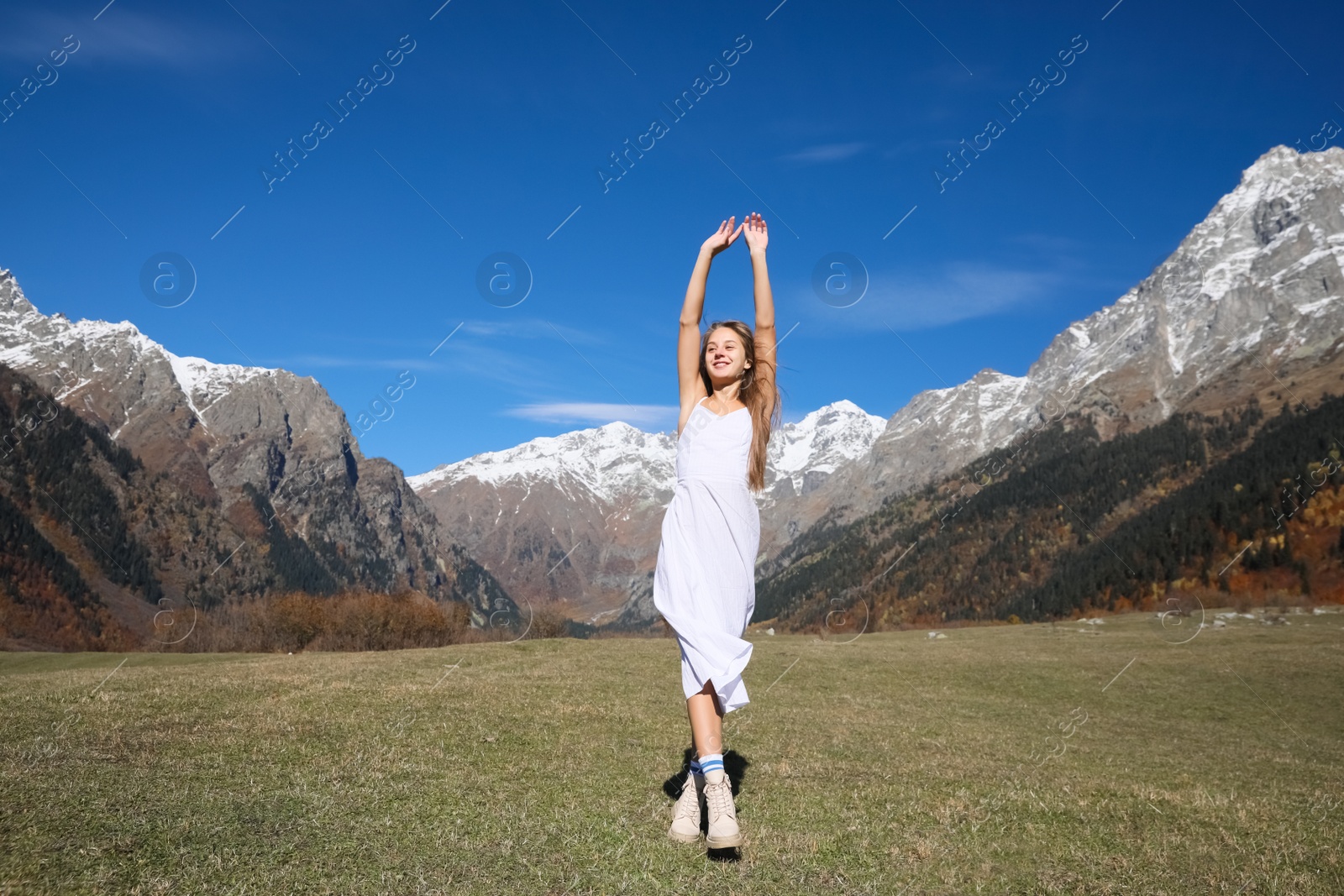 Photo of Young woman walking in beautiful mountains on sunny day