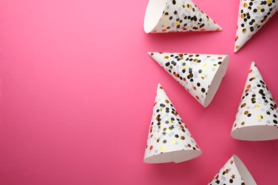Photo of Beautiful party hats on pink background, top view. Space for text